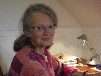 Harriet smiling and sitting at her desk.