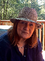 A photo of Roberta Arnold smiling and wearing a fedora